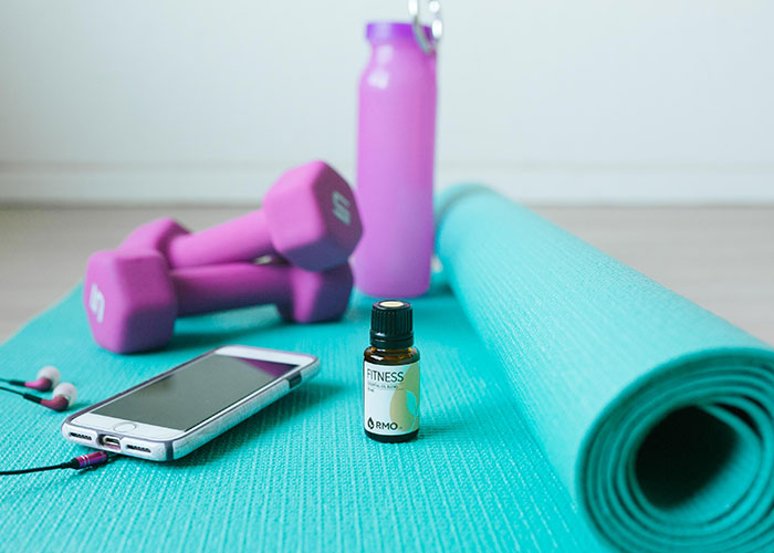 Essential Oils for Fitness yoga mat with water bottle dumbell and phone